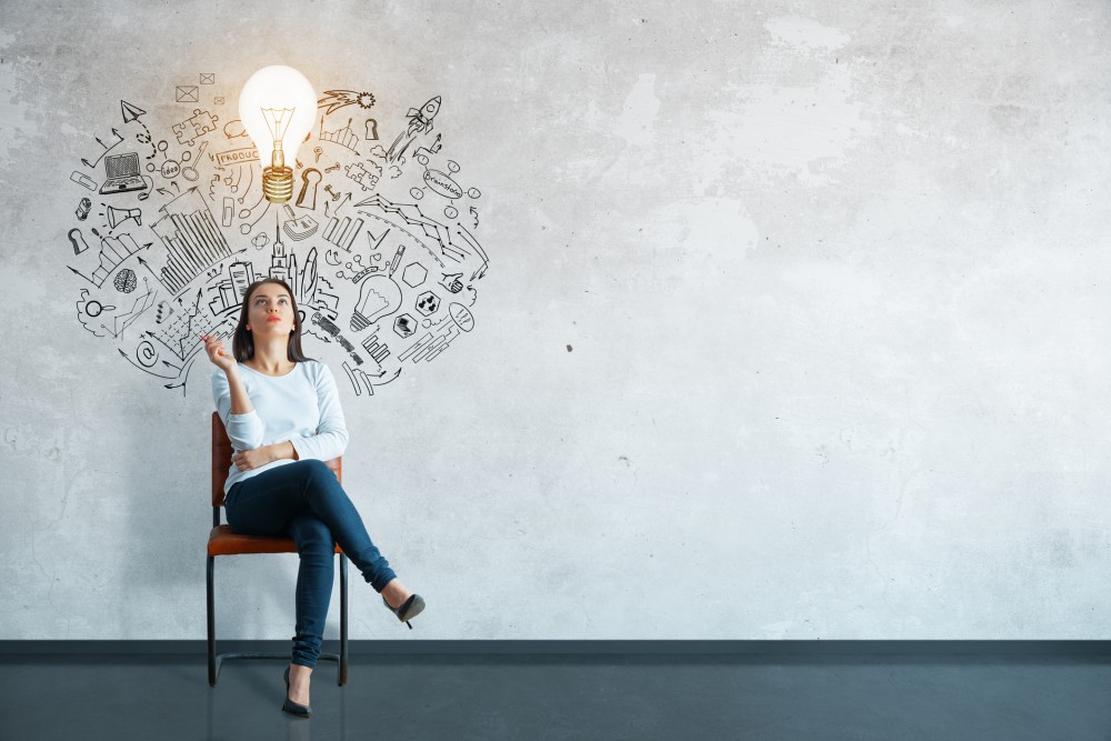 Thoughtful young woman sitting in concrete interior with creative business sketch and shadow. Leadership concept
