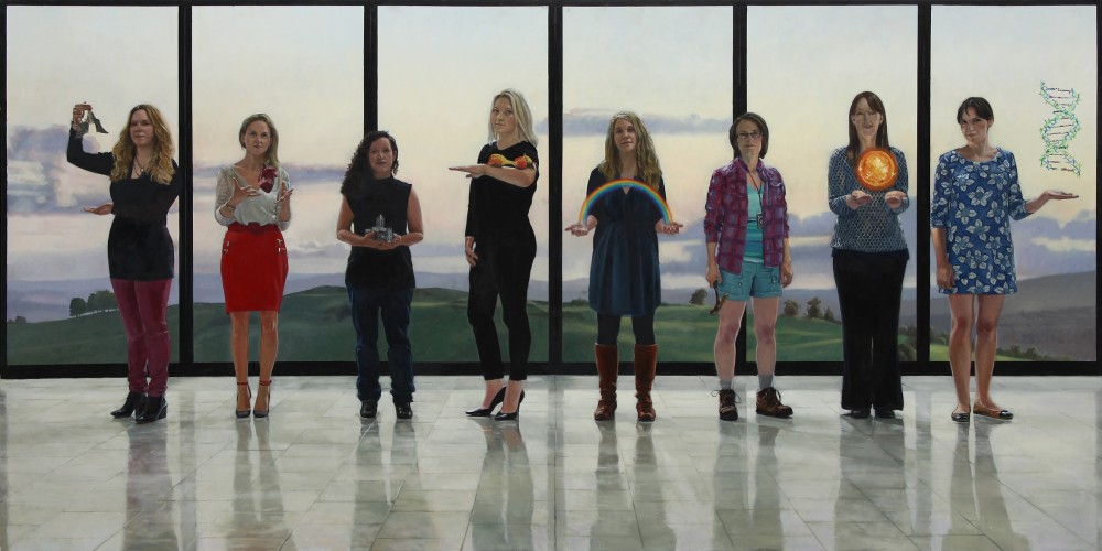 8 women stand in front of a window onto a green landscape. They each hold an item relating to science