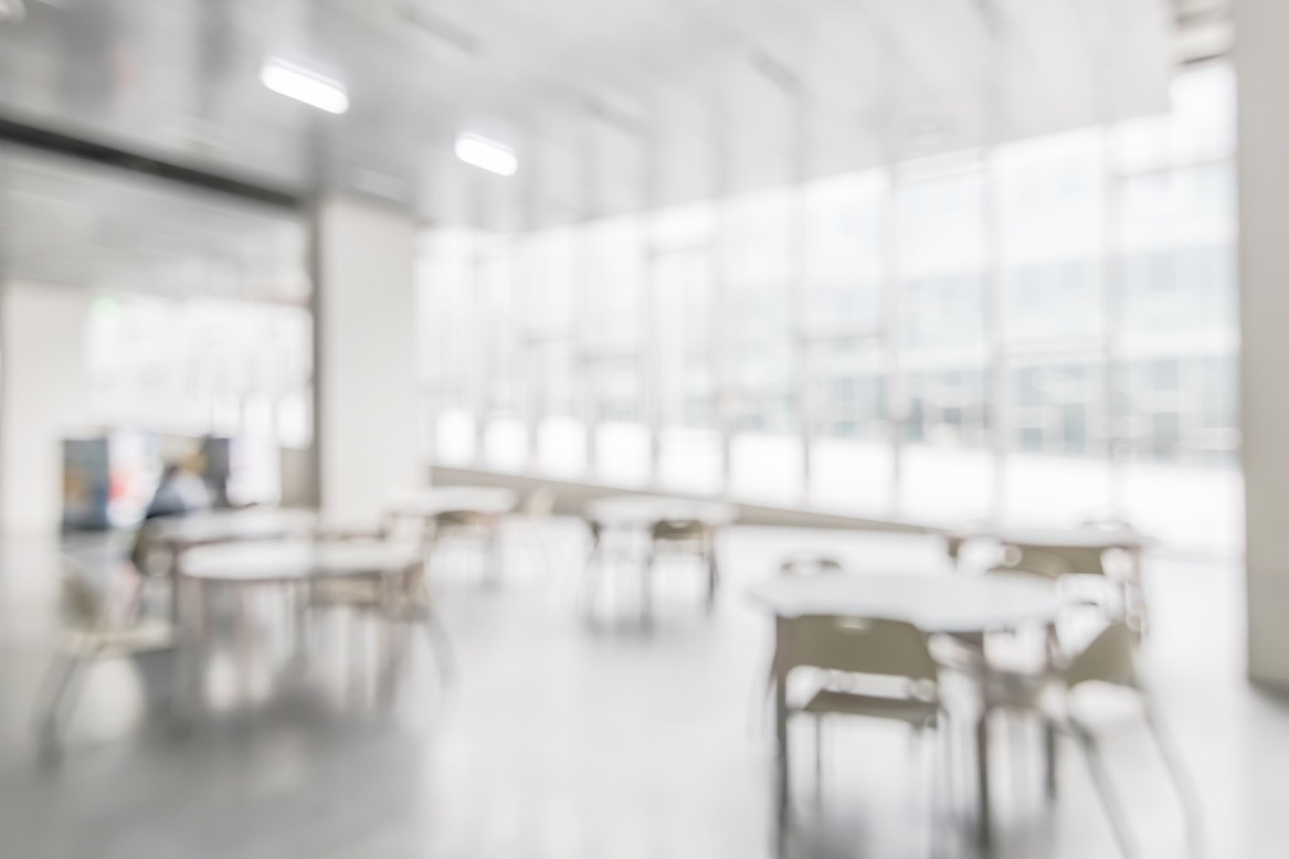 Out of focus image of an empty canteen with large windows