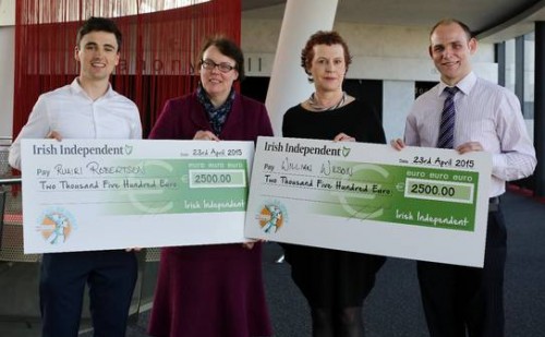 4 people pose for the camera holding two large cheques from the Irish Independent for a total of 5,000 euro