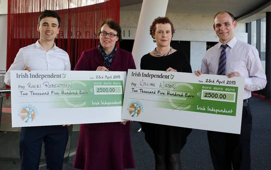 4 people pose for the camera holding two large cheques from the Irish Independent for a total of 5,000 euro