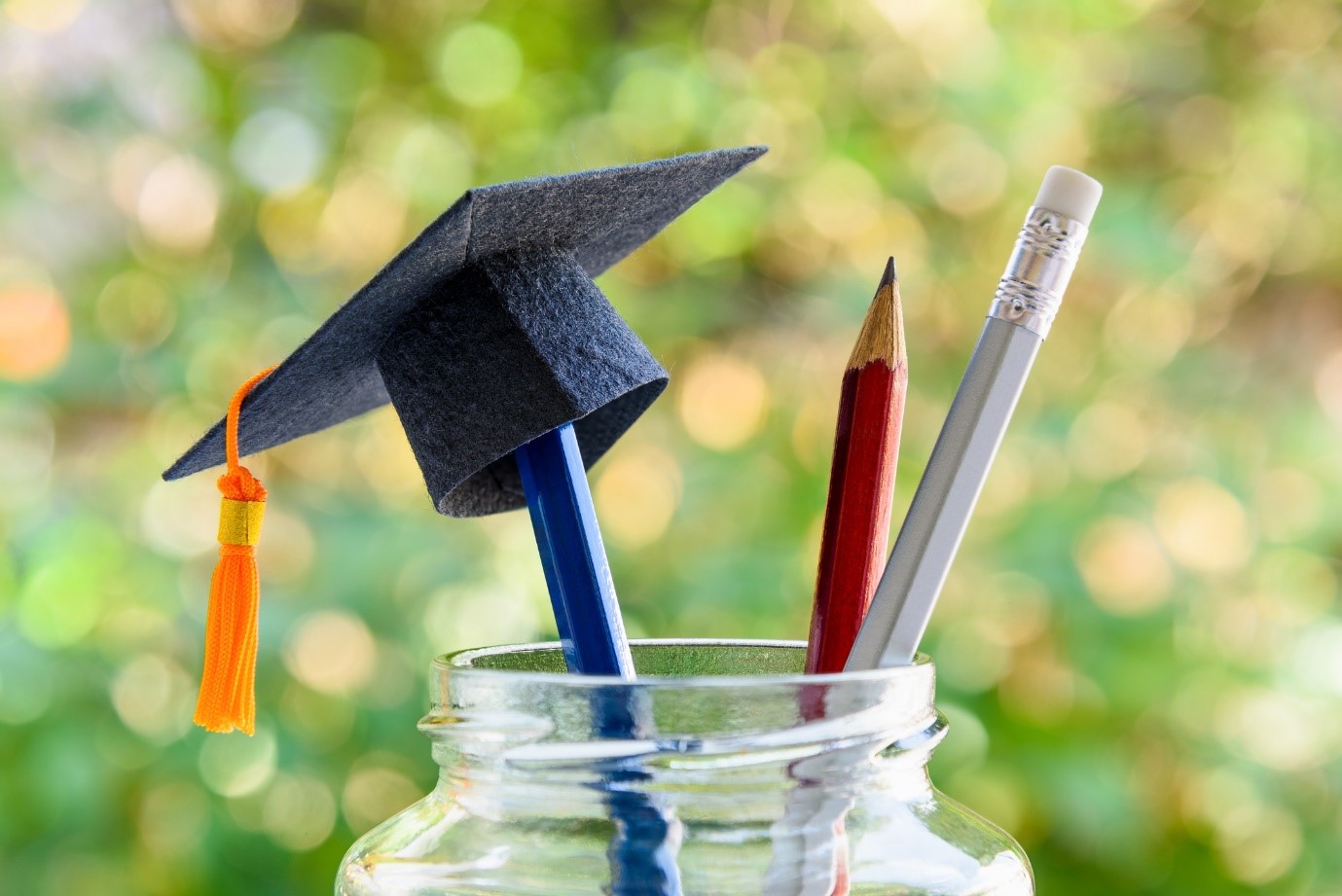 pencils in a jar with a mini felt graduation cap balancing on one of the pencils