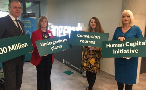 4 people standing next to each other holding signs reading 