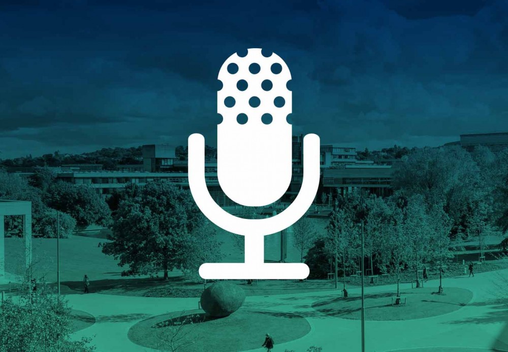 A white mic icon on top of an image of a college campus