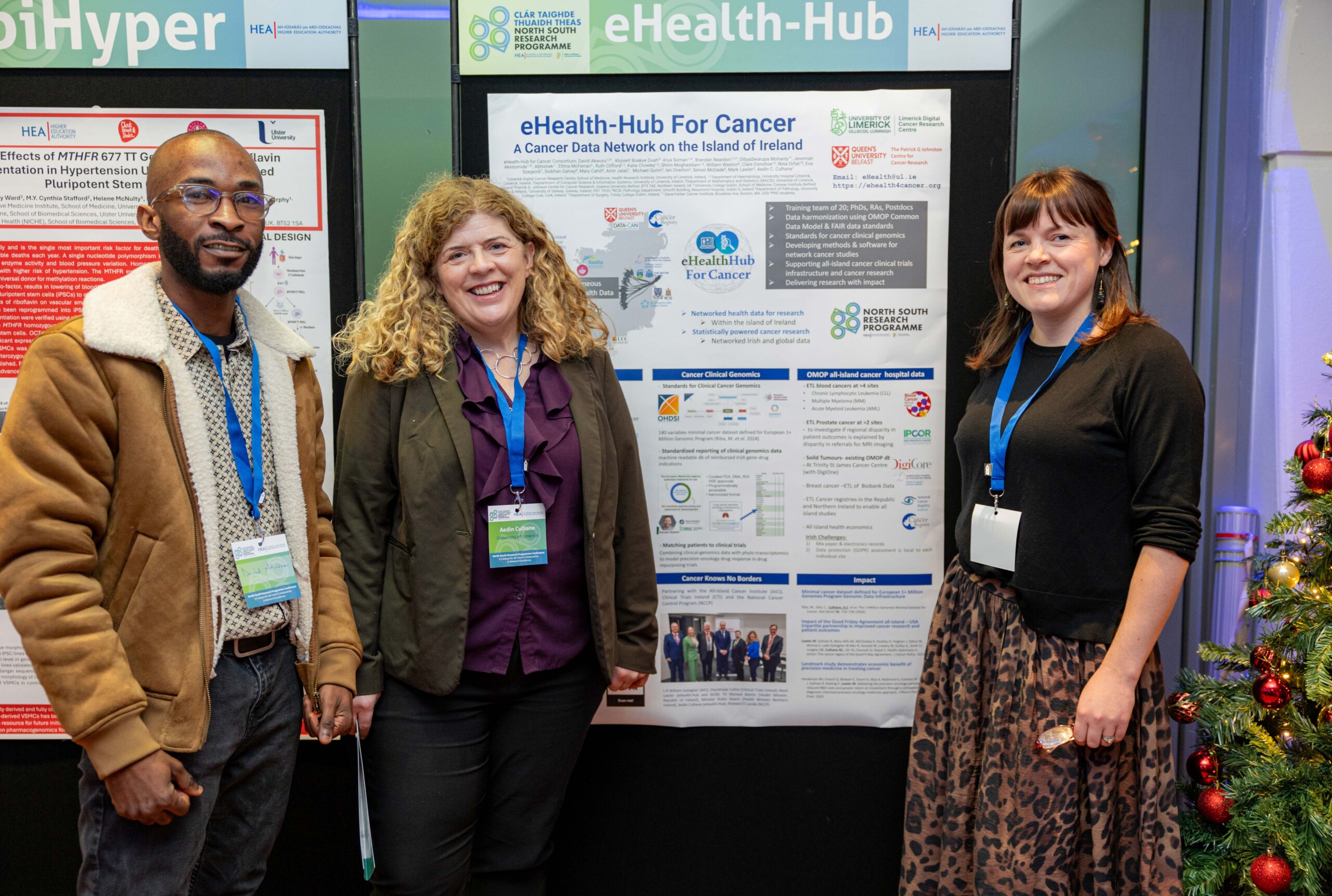 Three researchers posing in front of their project's poster