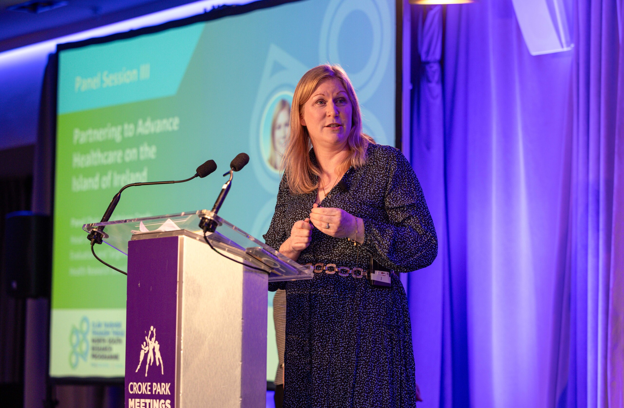 Dr Gillian McNaull of Ulster University, speaking on a podium at the North South Research Programme Conference, 2024 at Croke Park, Dublin.