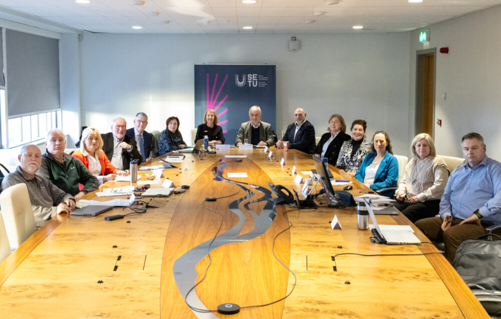 Image of the South East Technological University Governing Body and members of the HEA sitting in a boardroom discussing they universities development