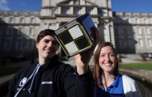 Image of 500w EIRSAT 1D held up by two students