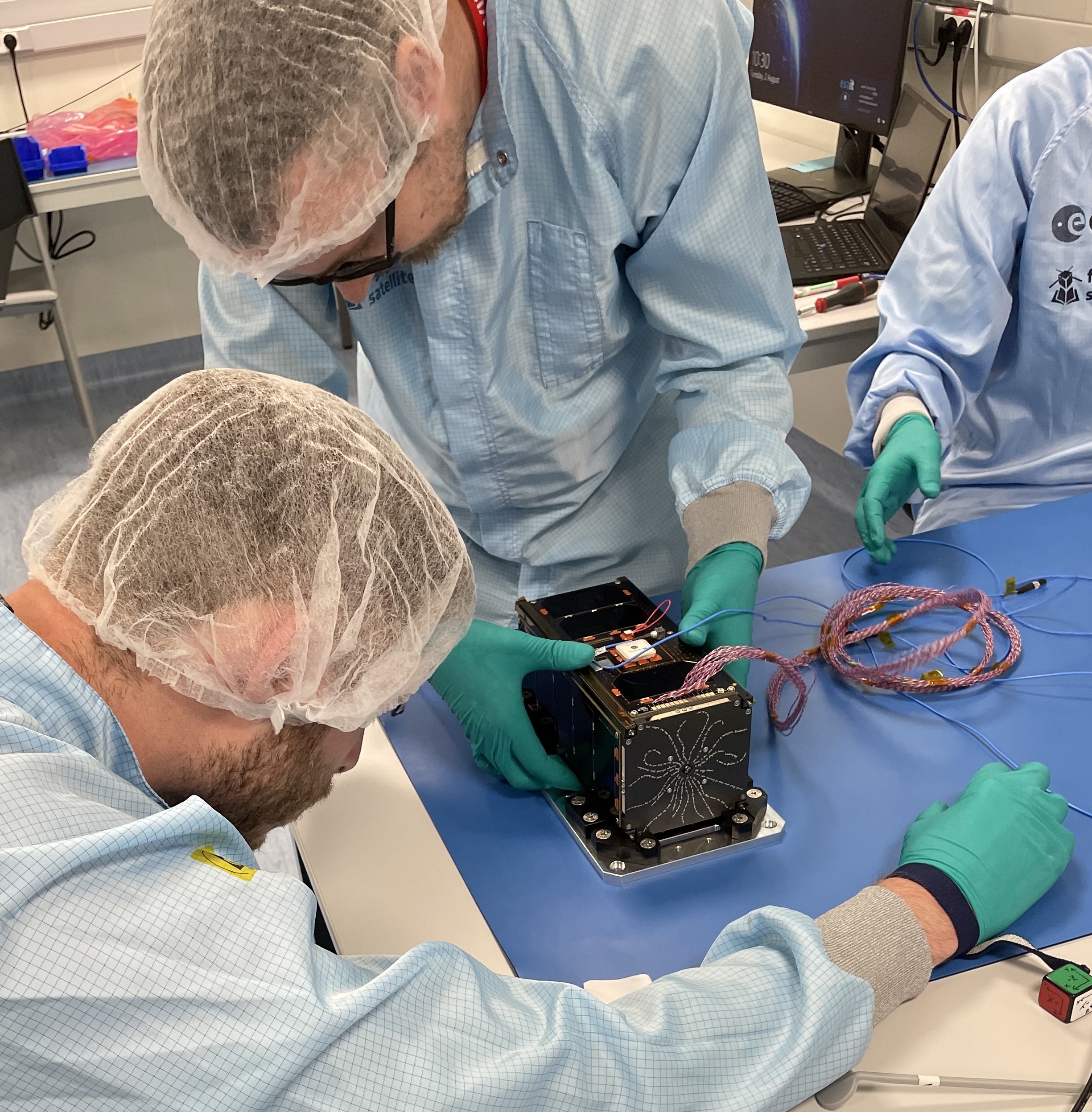 Image of EIRSAT-1 with Team working on it in a lab setting