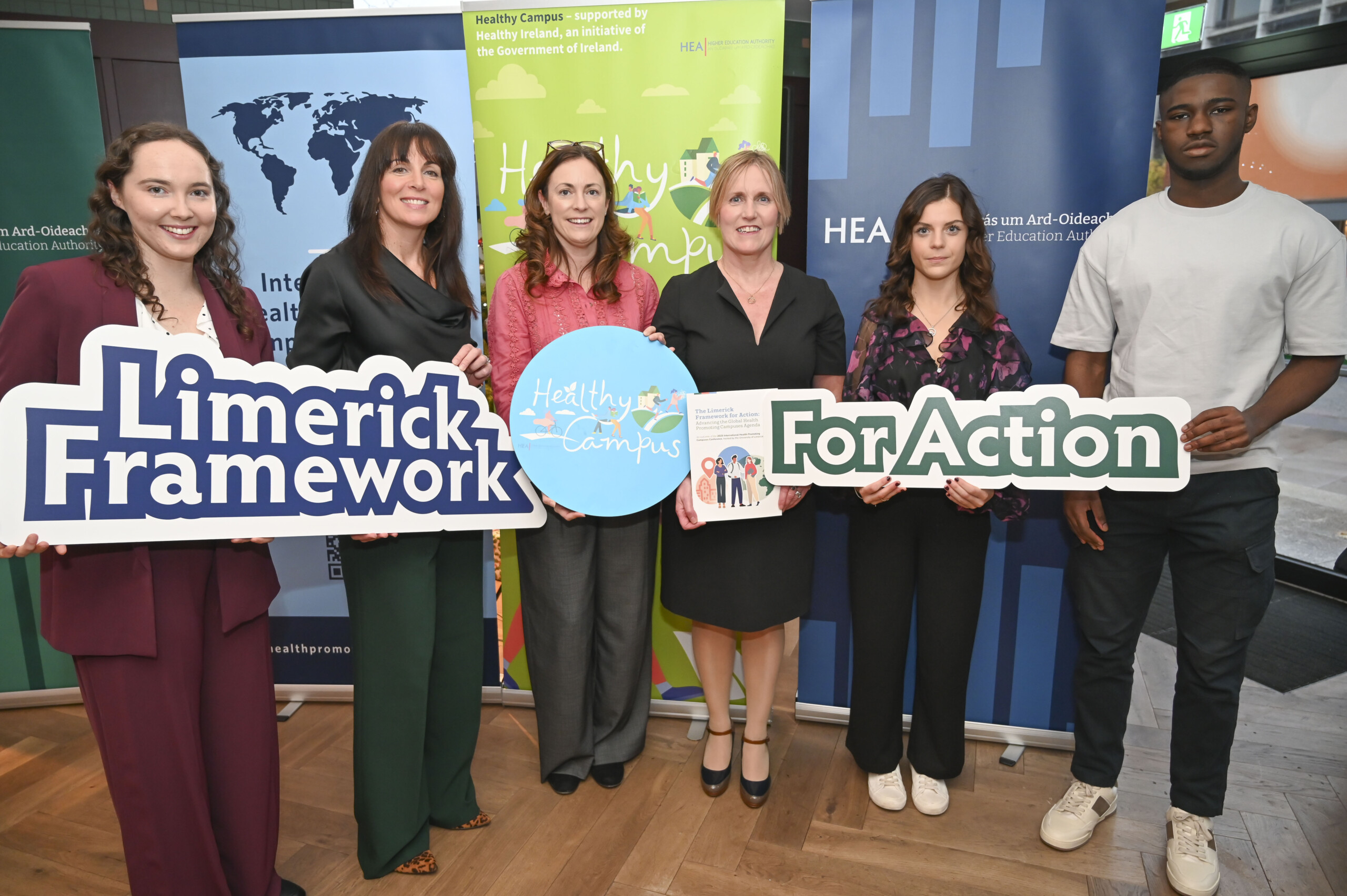 Group of people holding up banners at the Launch of the Limerick Framework for Action