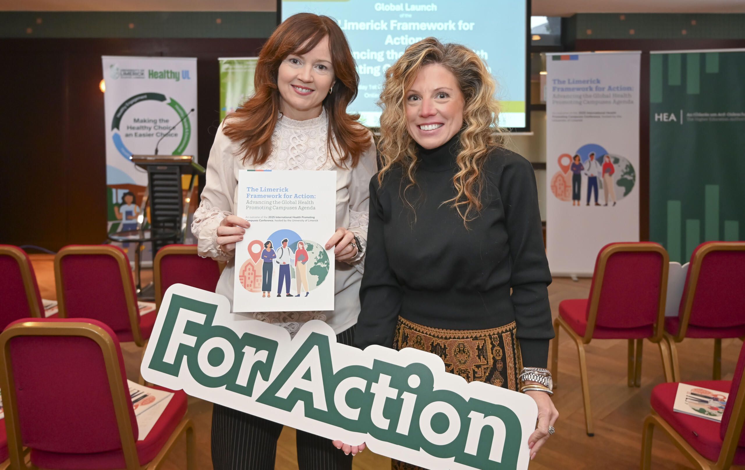 Two women holding up banners at the Launch of the Limerick Framework for Action