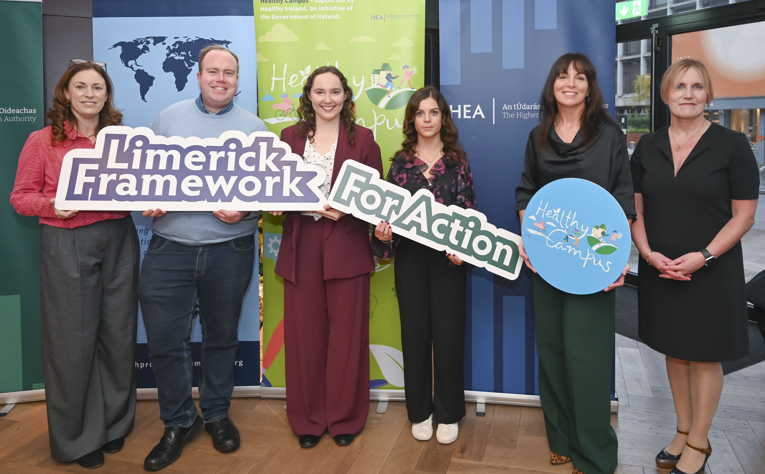 Group of people holding up banners at the Launch of the Limerick Framework for Action