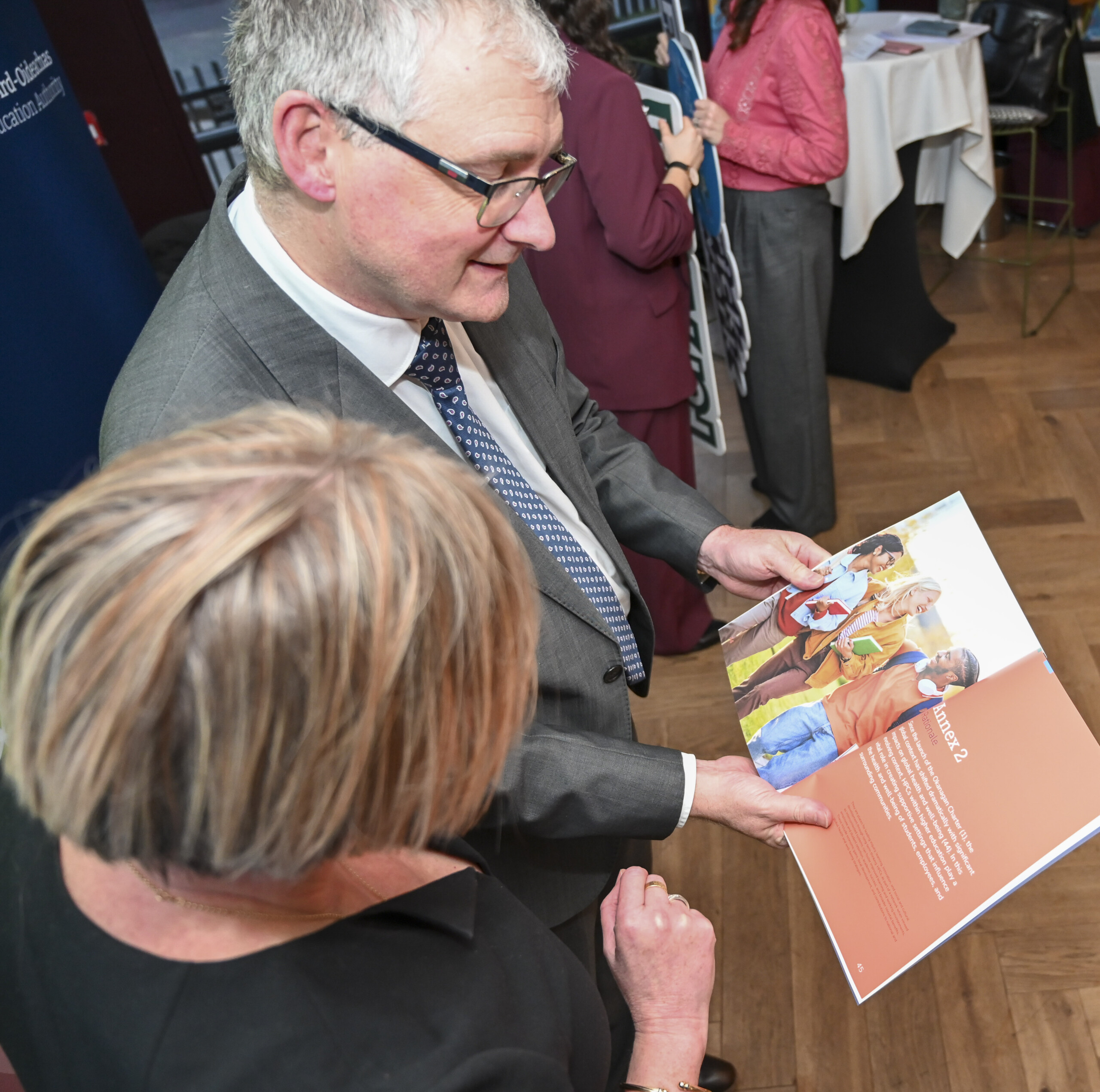 Man showing a copy of the Limerick Framework for Action booklet to a women