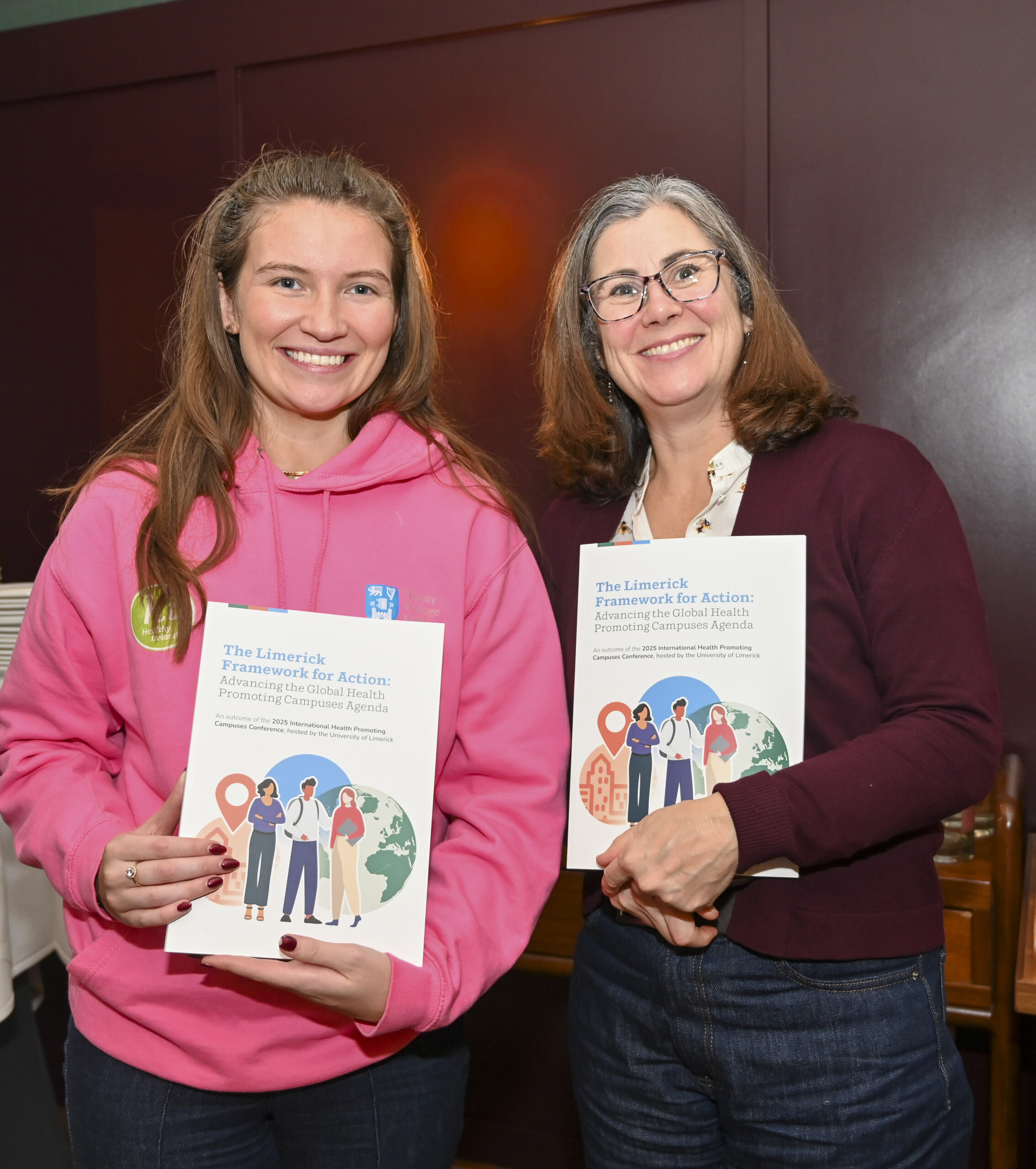 Group of people holding up booklets at the Launch of the Limerick Framework for Action