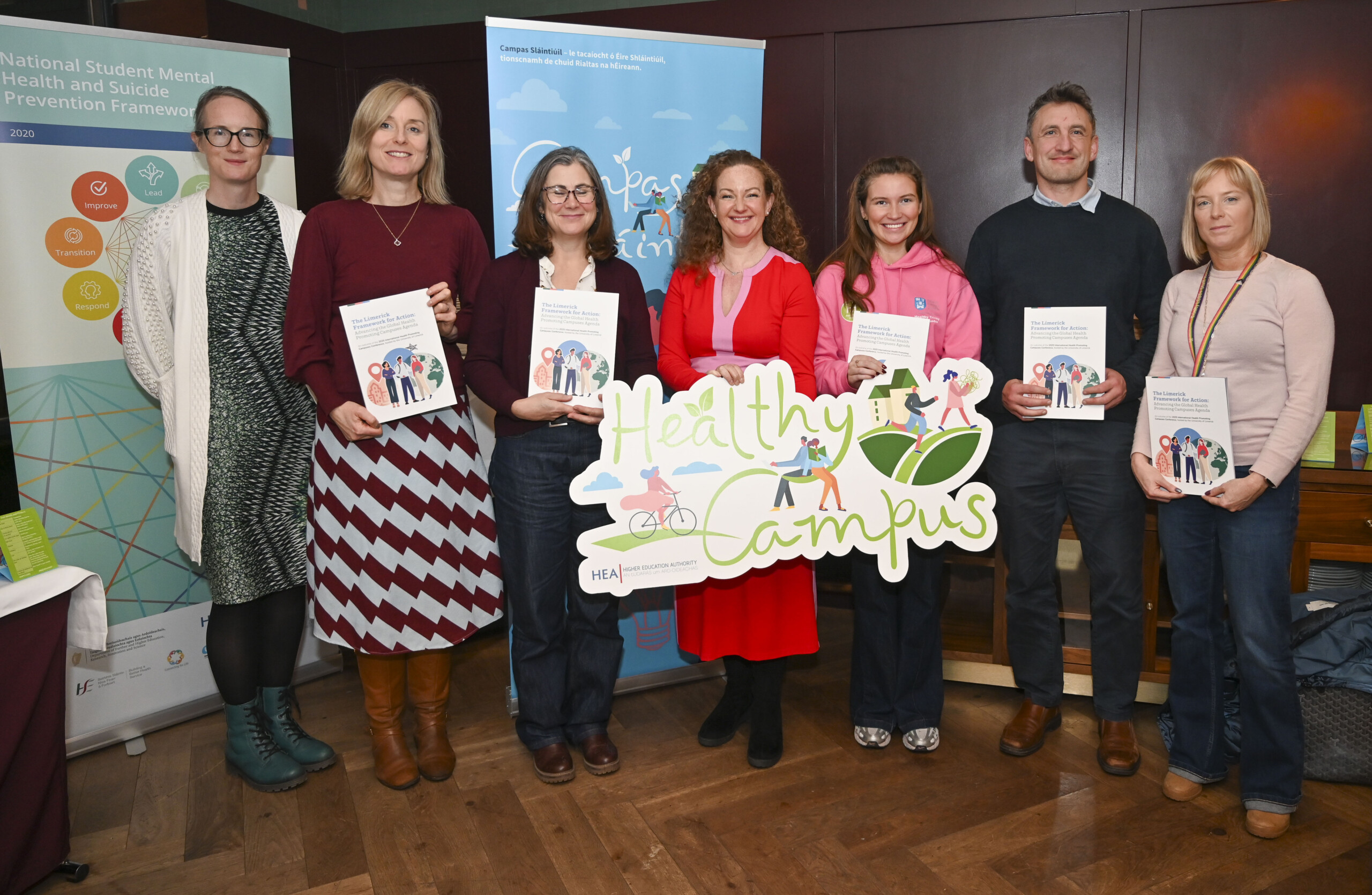 Group of people holding up banners and booklets at the Launch of the Limerick Framework for Action