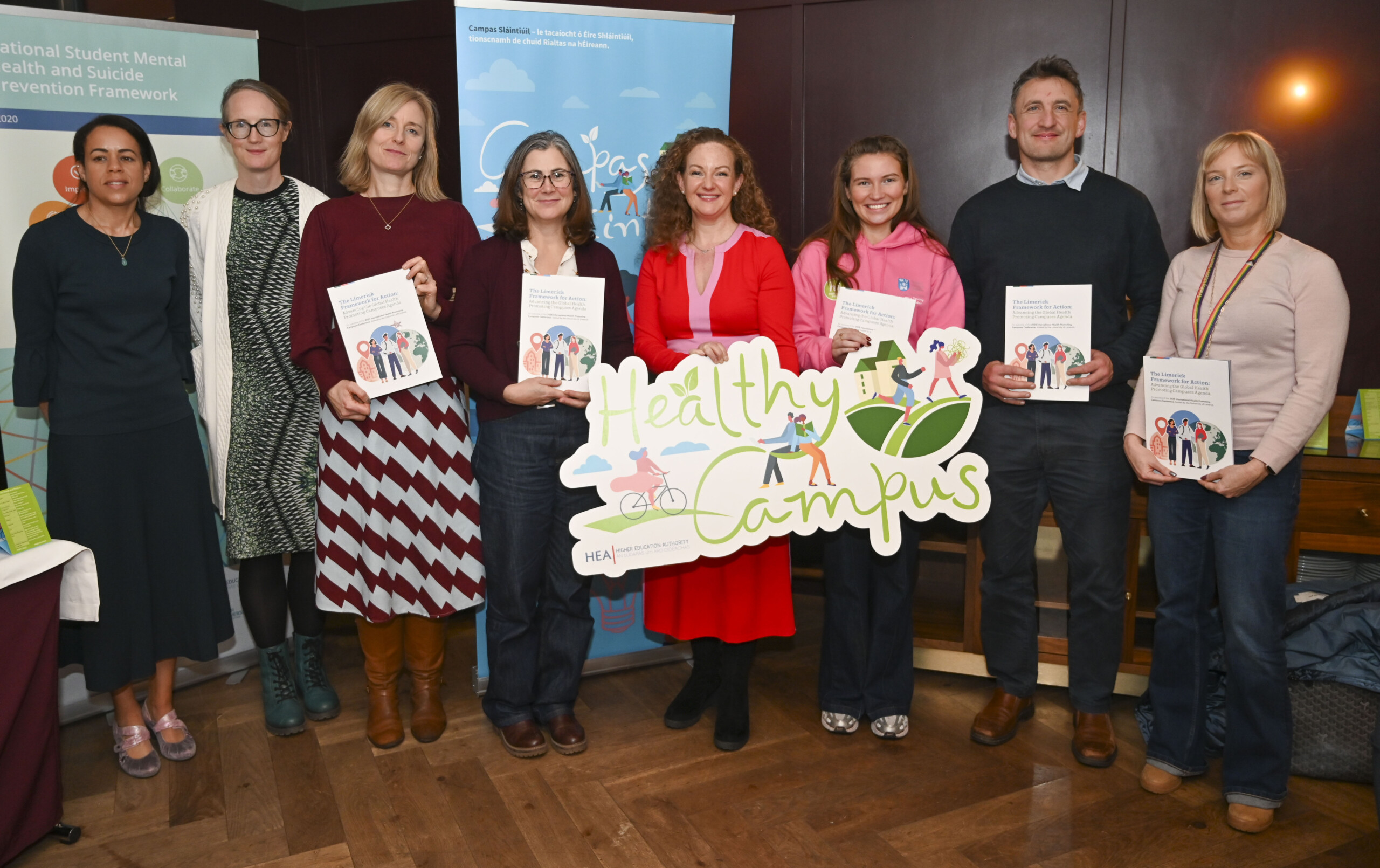 Group of people holding up banners and booklets at the Launch of the Limerick Framework for Action