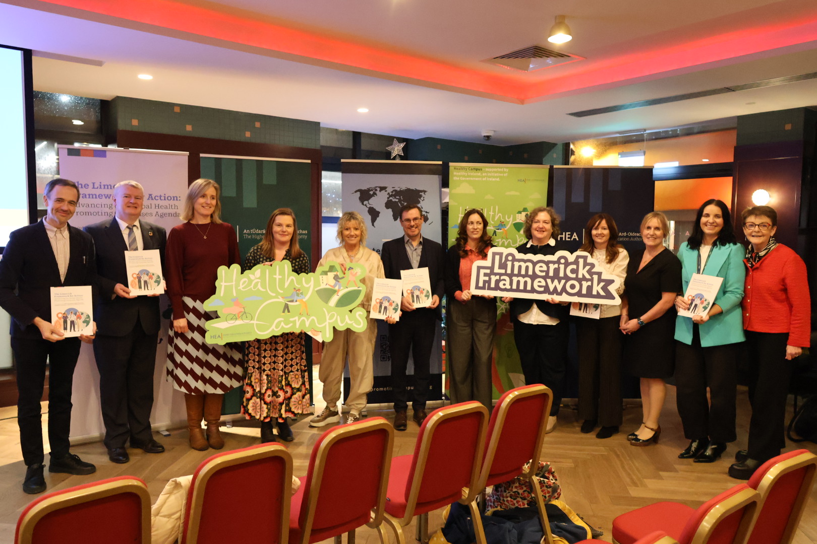 Group of people holding up banners and booklets at the Launch of the Limerick Framework for Action