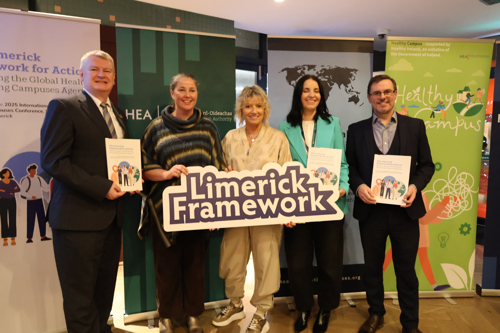 Group of people holding up banners and booklets at the Launch of the Limerick Framework for Action
