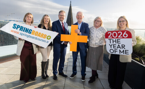 Group of six people posing holding handheld signs promoting Springboard+ 2026