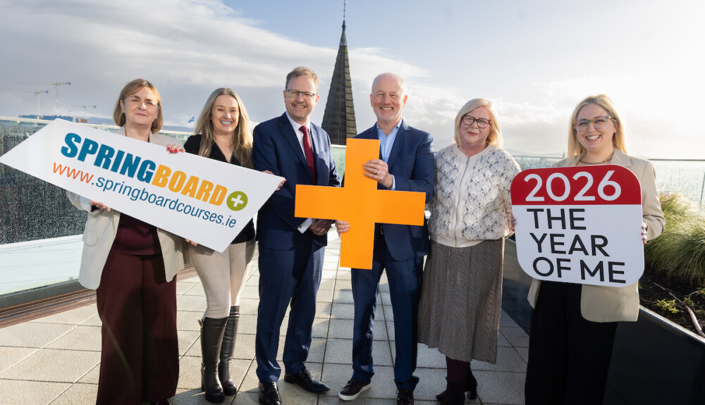Group of six people posing holding handheld signs promoting Springboard+ 2026