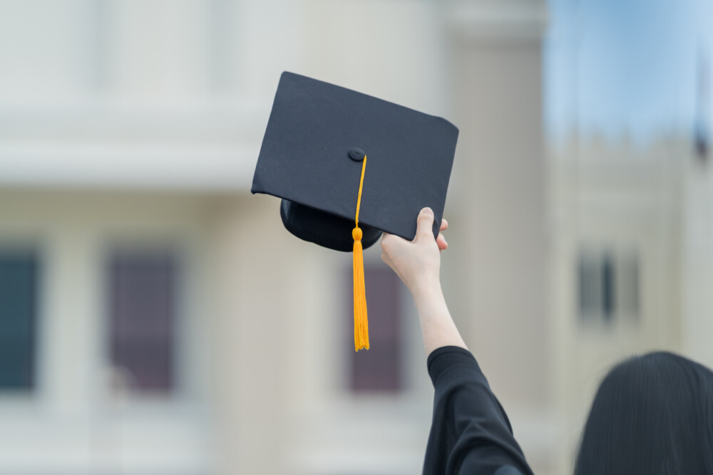 A hand holding a graduation hat