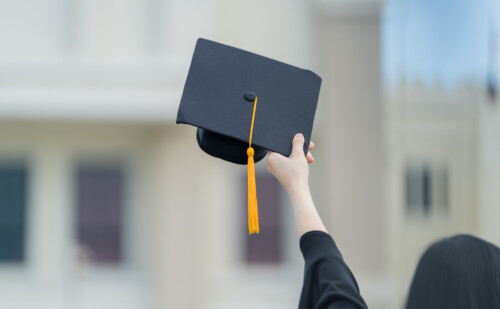 A hand holding a graduation hat